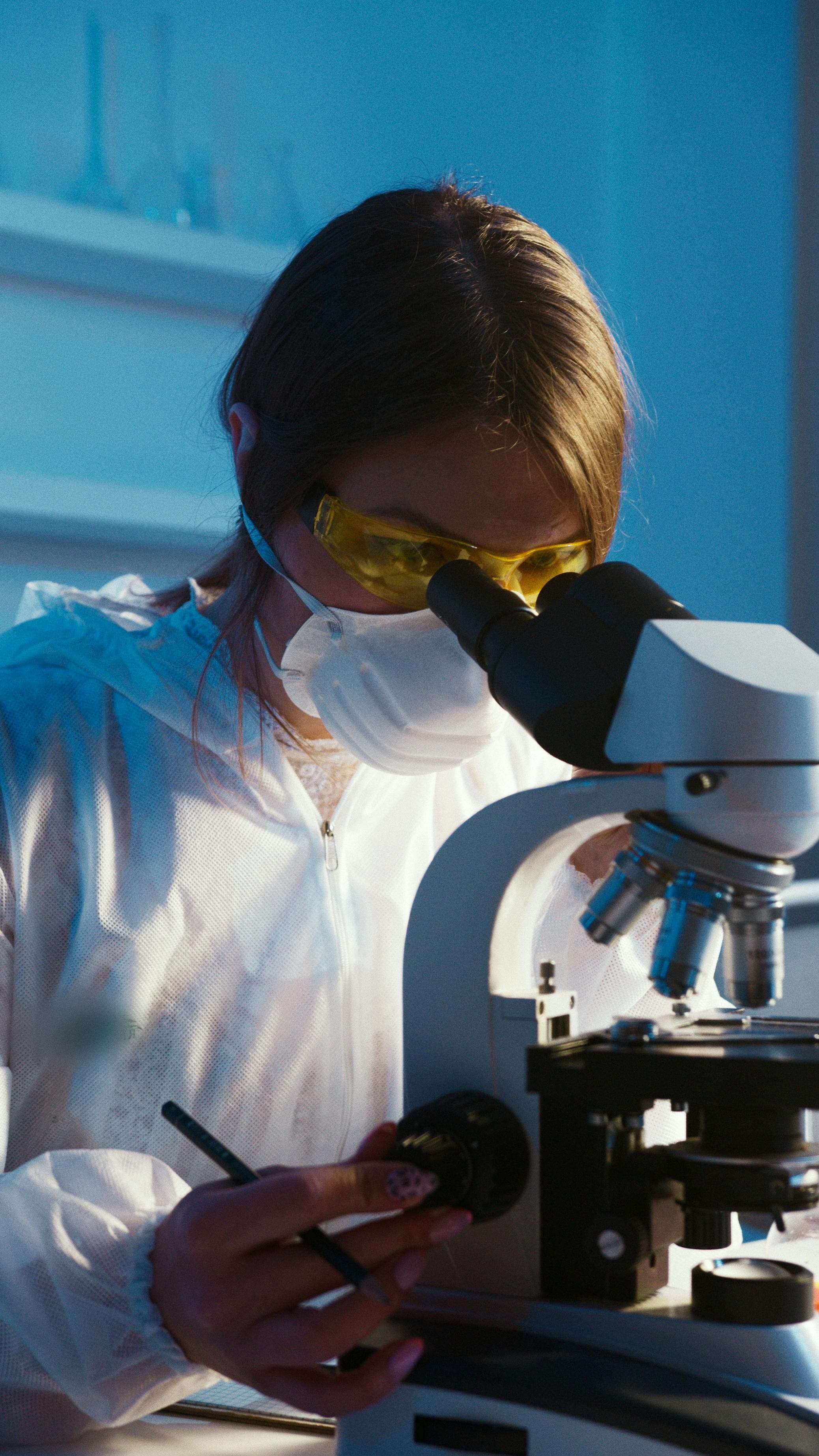 Medical researcher using a microscope